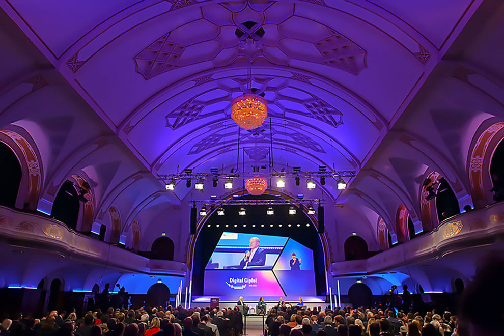Großer Konferenzsaal beim Digitalgipfel mit Bühne und Publikum