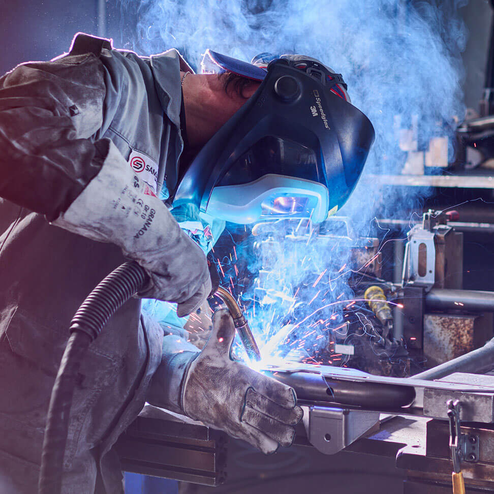 Mitarbeitender bei Schweißarbeiten in der industriellen Fertigung