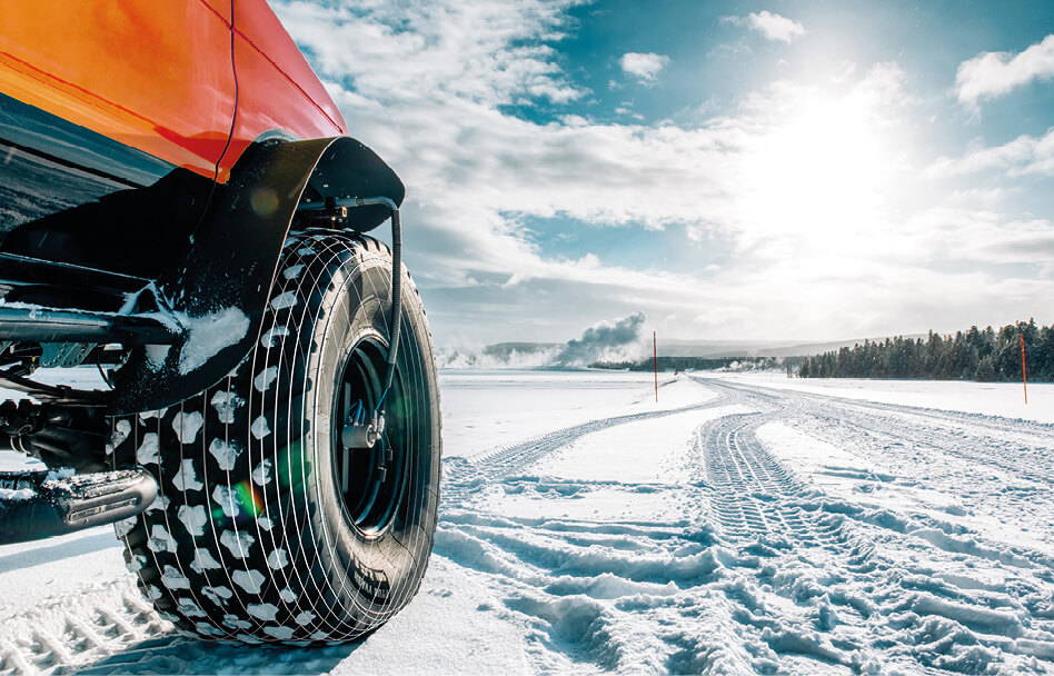 Geländefahrzeug mit Spezialreifen im winterlichen Einsatz auf verschneiter Strecke für Offroad- und Fahrzeugtechnik