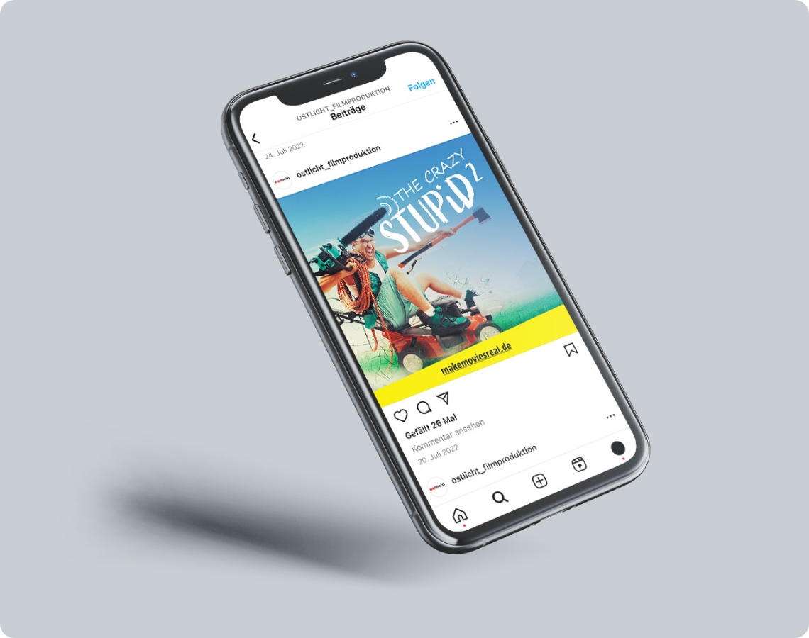 Smartphone zeigt einen Social-Media-Beitrag von Ostlicht Filmproduktion mit einem Filmplakat aus einer Recruitingkampagne für Filmberufe