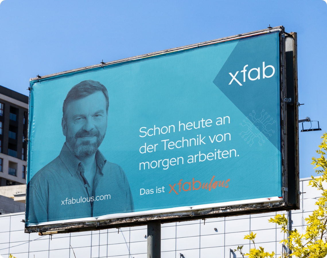Großes Außenplakat des Technologieunternehmens X-FAB mit Porträt eines Mitarbeiters und der Botschaft, schon heute an der Technik von morgen zu arbeiten