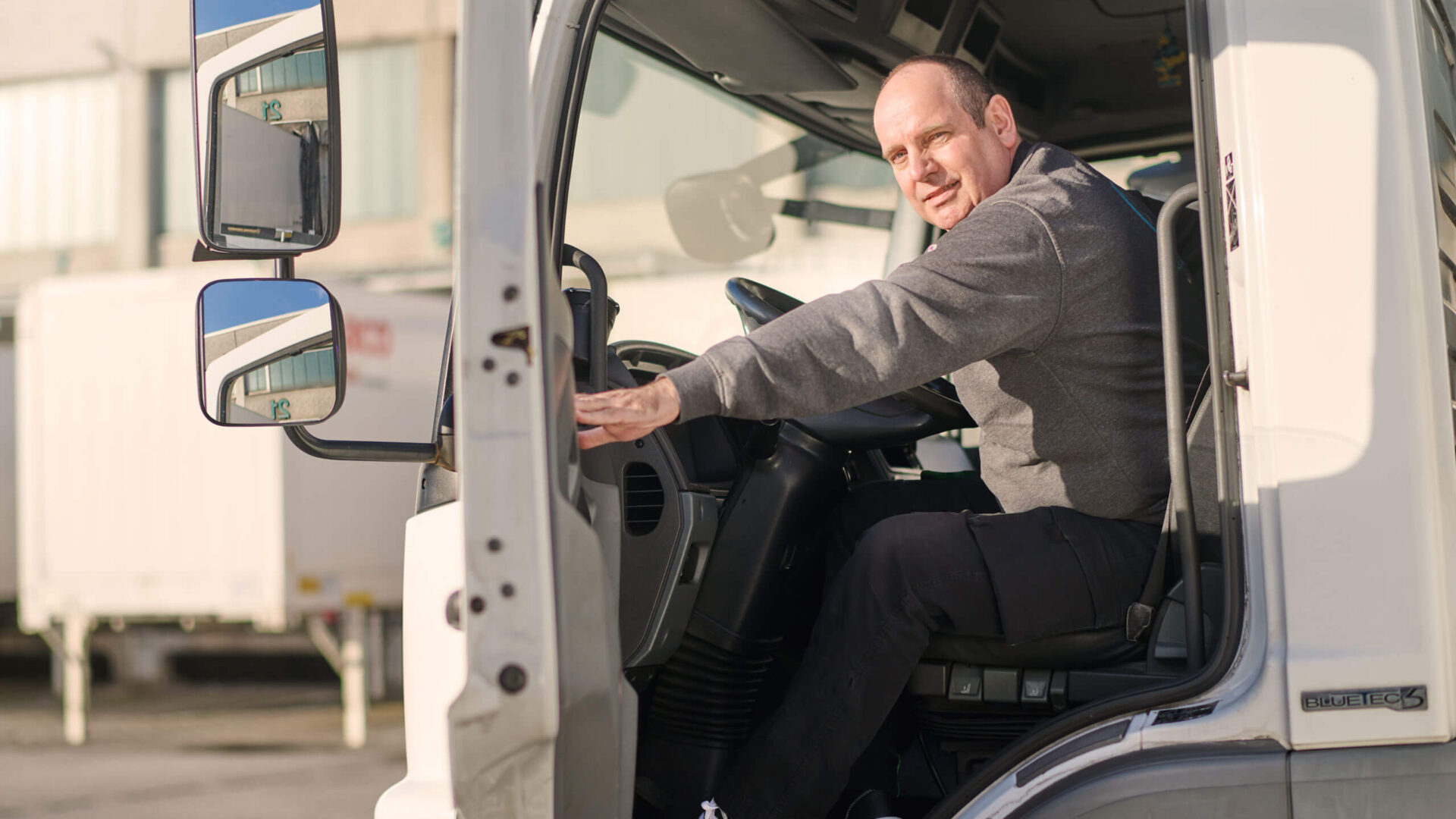 Lkw-Fahrer sitzt in der Fahrerkabine eines Transportfahrzeugs