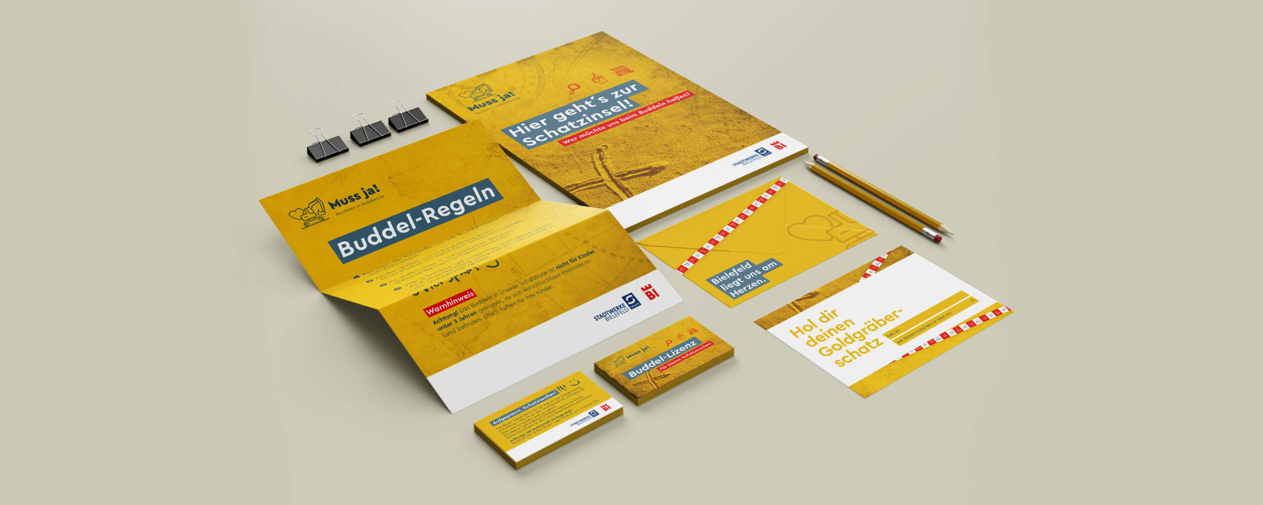 Aktionsmaterialien der Kampagne „Muss ja!“ mit Flyern, Karten und Spielunterlagen zur Mitmachaktion rund um Baustellen in Bielefeld