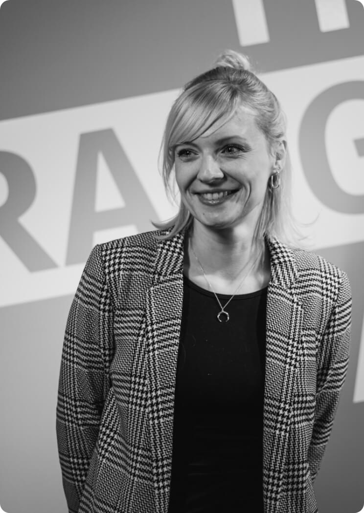 Porträt einer lächelnden Mitarbeiterin vor Unternehmensbranding als Bildmotiv für Teamvorstellung und Arbeitgebermarke