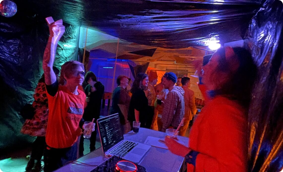 51 DJ-Pult mit Musik und tanzenden Gästen bei Indoor-Event als Bildmotiv für Veranstaltung und Partyatmosphäre