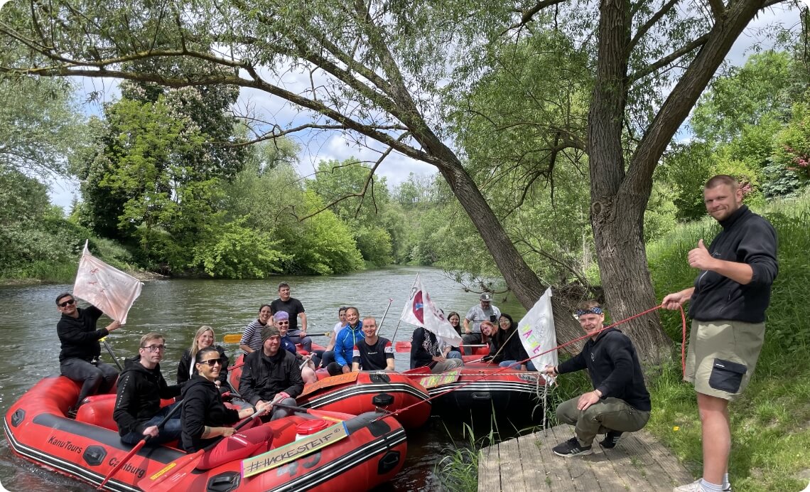 54 Teamgruppe bei gemeinsamer Kanutour auf einem Fluss als Bildmotiv für Teamevent und Betriebsausflug