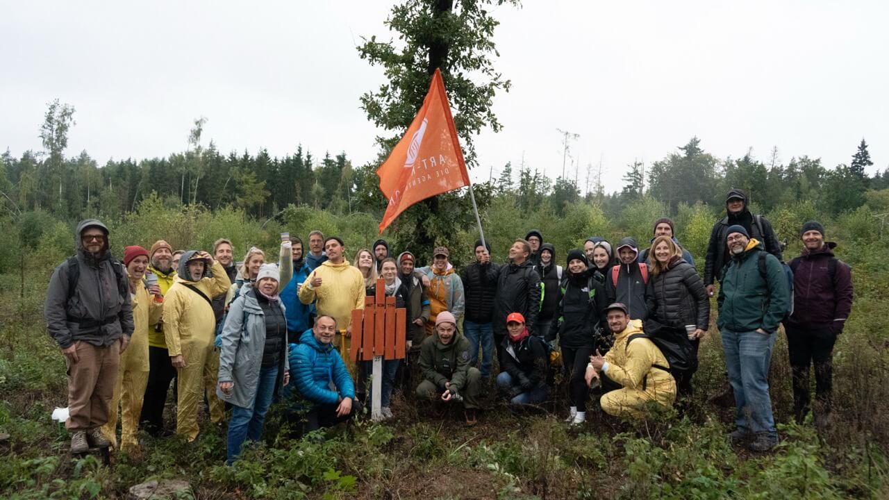 Große Teamgruppe bei Outdoor-Teamevent im Wald als Bildmotiv für Zusammenarbeit und gemeinschaftliches Engagement